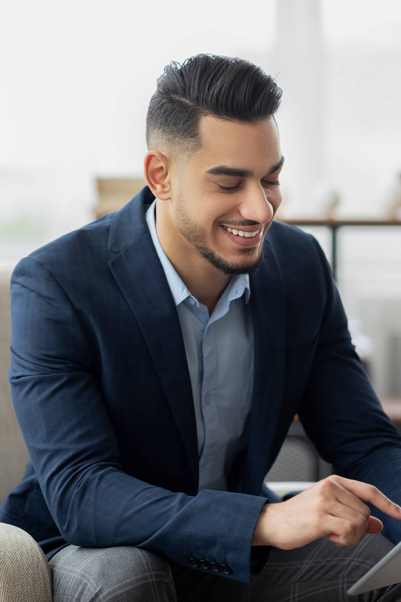 Specialist from abroad sits and types on a tablet