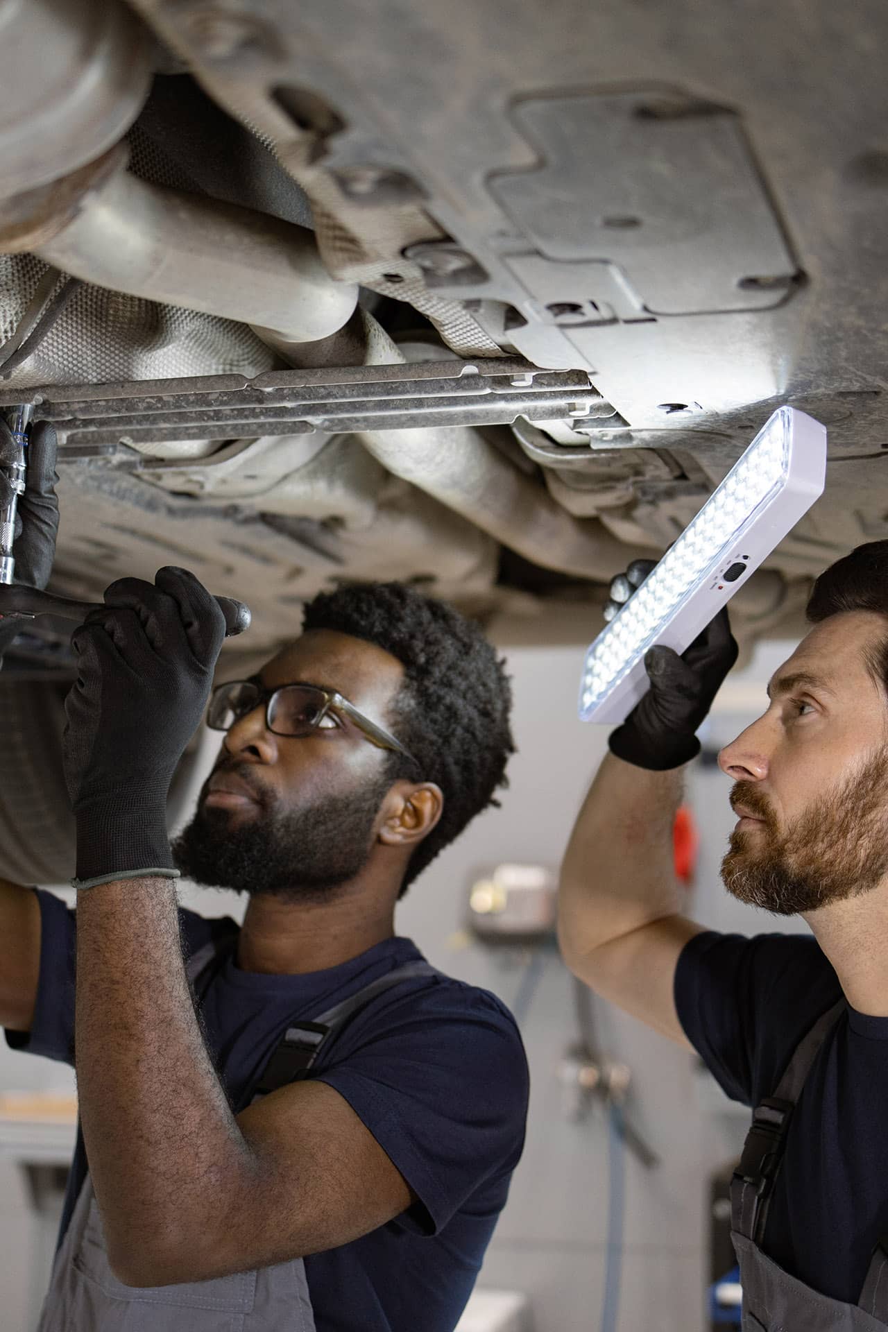 Black mechanic Skilled worker from abroad examines a car